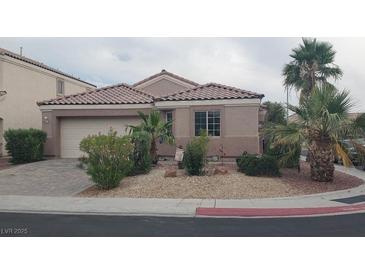 Charming single-story home with desert landscaping, tile roof, and a paved driveway leading to the garage at 449 Orchid Oasis Ave, North Las Vegas, NV 89031