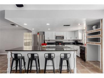 Bright kitchen features a large island with bar seating and stainless steel appliances at 5905 Paseo Montana, Las Vegas, NV 89108