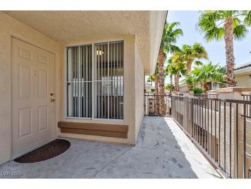 Welcoming front entrance with door, security screen, and palm trees lining the walkway in a well-maintained community at 7155 S Durango Dr # 303, Las Vegas, NV 89113