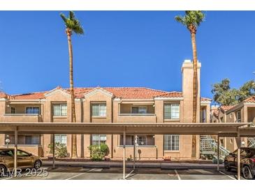 Attractive condo building with terracotta tile roof, beige facade, balconies, and shaded parking area at , Las Vegas, NV 89119