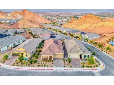 Scenic street view showcasing homes with desert landscaping and mountain views in a vibrant community at 32 Tatahatso Point St, Henderson, NV 89011