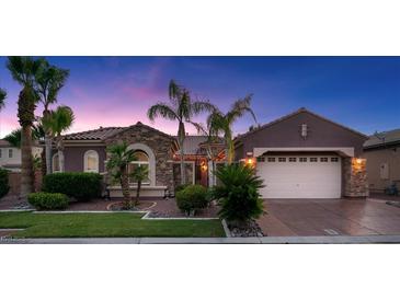 Charming single-story home featuring stone accents, a two-car garage, and well-manicured landscaping at 8209 Chapelle Ct, Las Vegas, NV 89131