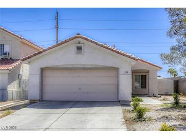 Charming single-story home with a two-car garage and low maintenance landscaping in a suburban neighborhood at 1320 Rainbow Meadows Dr, Las Vegas, NV 89128