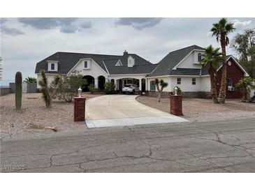 Stately home featuring a brick-lined driveway leading to a portico entrance and a well-manicured, xeriscaped front yard at 156 N Parawan St, Henderson, NV 89015
