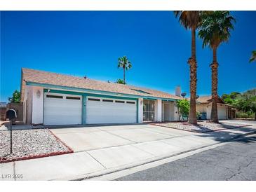 Charming single-story home featuring a two-car garage, mature landscaping, and blue skies in a quiet neighborhood at 4774 Walteta Way, Las Vegas, NV 89119