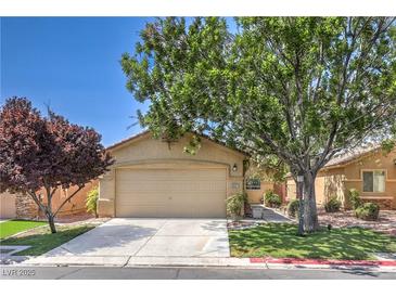 Charming single-story home featuring a well-manicured front yard with mature shade trees and a two-car garage at 5687 Harbour Pointe Ave, Las Vegas, NV 89122