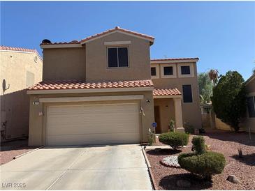 Charming two-story home featuring a two-car garage and desert landscaping under a clear blue sky at 977 Country Skies Ave, Las Vegas, NV 89123