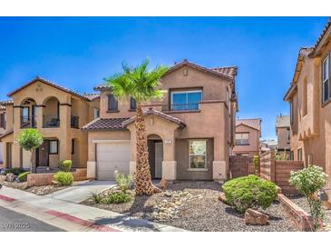 Charming two-story home features a desert landscape, a private two-car garage, and mature palm trees at 1097 Paradise Resort Dr, Henderson, NV 89002