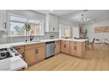 Bright, modern kitchen featuring wood cabinets, stainless steel appliances, and a large window overlooking the yard at 2532 Big Timber Dr, Las Vegas, NV 89134