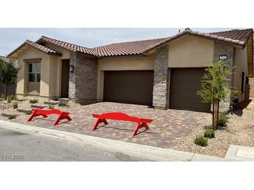 Charming single-story home with a two-car garage, beautiful stone accents, and decorative front yard benches at 344 Tigullio Ave, Henderson, NV 89011