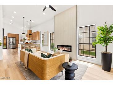 Bright living room featuring a fireplace, modern furniture, and hardwood floors at 4856 Fiesta Lakes St, Las Vegas, NV 89130