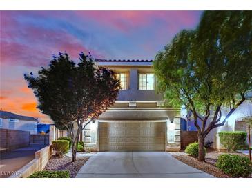Charming home featuring a two-car garage, desert landscaping, and a picturesque sunset backdrop at 6187 Novelty St, Las Vegas, NV 89148