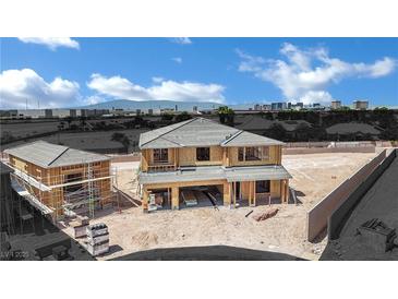 New construction home showing wood framing and a detached garage in a desert setting with city views at 7118 Painted Skyline St, Las Vegas, NV 89118