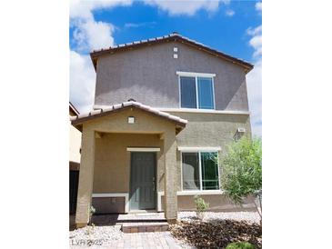 Charming two-story home with a covered porch and neutral stucco exterior under a partly cloudy sky at 7411 Sunray Point St, North Las Vegas, NV 89084