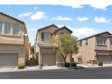 A quaint two-story home with a tan exterior, featuring a single-car garage and mature landscaping at 8448 Quarentina Ave, Las Vegas, NV 89149