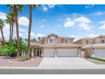 Charming two-story home with a well-manicured lawn, palm trees, and a three car garage at 9500 Catalina Cove Cir, Las Vegas, NV 89147