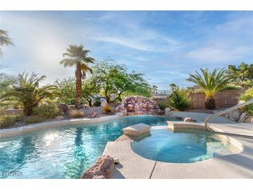 Beautiful pool area featuring a rock waterfall, spa, and lush landscaping at 1239 N Hollywood Blvd, Las Vegas, NV 89110