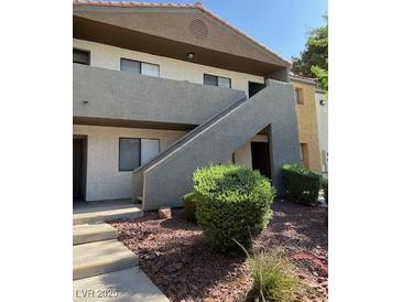Charming two-story condo with well-maintained landscaping and gray stucco accents at 3151 Soaring Gulls Dr # 2050, Las Vegas, NV 89128