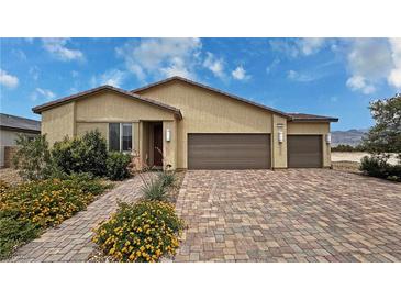 Charming single-story home with desert landscaping and a brick driveway to the attached garage at 5528 Eleganza Ave, Pahrump, NV 89061