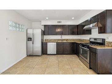 A kitchen featuring stainless steel appliances and granite countertops with tile flooring at 882 Westminster Ave, Las Vegas, NV 89119