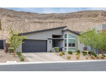 Modern home with a flat roof, two-car garage, desert landscaping, and mountain views at 9789 Twilight Moon Ave, Las Vegas, NV 89148