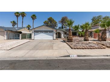 Single-story home with a two-car garage, mature landscaping, and a well-maintained front yard at 813 Cherry Dr, Henderson, NV 89002