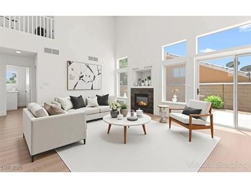 Bright living room with fireplace, modern decor, and large windows providing natural light at 9011 Aldershot Ct, Las Vegas, NV 89147