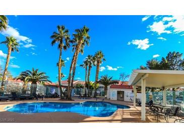 Community pool featuring lounge chairs, palm trees, and a covered seating area, perfect for relaxation at 2725 S Nellis Blvd # 2005, Las Vegas, NV 89121