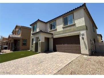 Two story home showcasing a two car garage, paved driveway and low maintenance artificial grass at 4104 Free Bird Crest Ave, North Las Vegas, NV 89081
