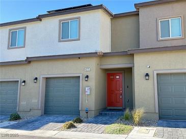 Beautful townhouse featuring an attached garage, stone details and a bright red front door at 4273 Venus Falls Ave, North Las Vegas, NV 89084