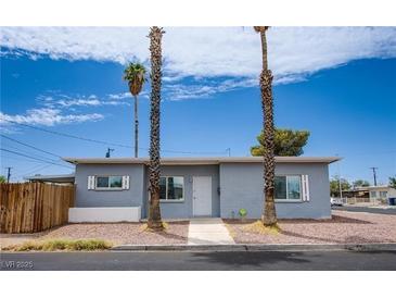 Charming single-story home featuring a manicured yard and a welcoming entrance with beautiful palm trees at 4831 Vermont Ave, Las Vegas, NV 89107