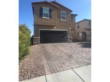 Inviting two-story home featuring a finished two-car garage and a beautifully paved driveway at 9163 W Torino Ave, Las Vegas, NV 89148