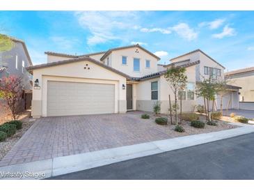 Beautiful home featuring a paver driveway and two-car garage, complemented by manicured landscaping at 19 Cresta Villa Ct, Henderson, NV 89011