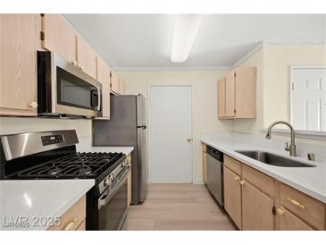 Well-lit kitchen with stainless steel appliances and light wood cabinets and white countertop at 7885 W Flamingo Rd # 1131, Las Vegas, NV 89147