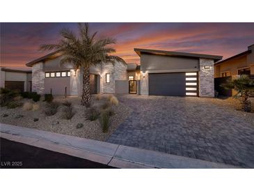 Modern exterior showcasing desert landscaping, a paved driveway, and a two-car garage at sunset at 794 Willits St, Las Vegas, NV 89138
