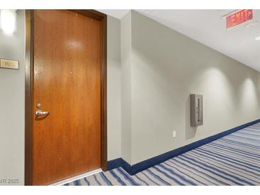Hallway with an exit sign and a blue striped carpet near the door to unit 722 at 8255 Las Vegas Blvd # 722, Las Vegas, NV 89123
