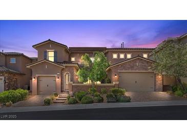 Charming two-story home featuring a well-maintained landscape, brick accents, and attached garages at 12269 Catanzaro Ave, Las Vegas, NV 89138