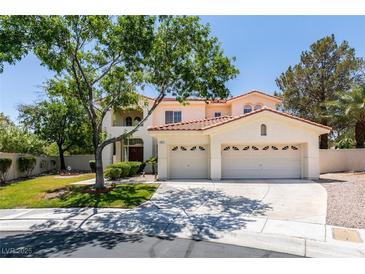 Charming two-story home with a three-car garage, tiled roof, and a well-manicured front lawn, perfect for suburban living at 1813 Francisco Peak Pl, Las Vegas, NV 89128