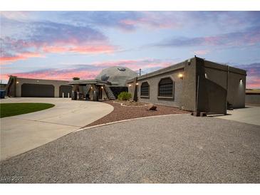 Unique home with a dome feature, covered area, and expansive driveway at dusk at 7215 Ullom Dr, Las Vegas, NV 89118