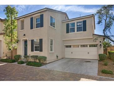 Charming two-story home featuring a brick driveway, attached two-car garage, and a well-manicured front yard at 8353 Lower Trailhead Ave, Las Vegas, NV 89113