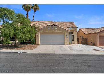 Charming single-story home with a two-car garage, desert landscaping, and a tile roof at 920 Serpentina Ave, Las Vegas, NV 89123