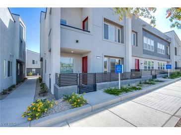 Modern two-story townhome featuring a balcony, fenced yard, and contemporary architectural details at 31 Newport Edge Pl, Henderson, NV 89015
