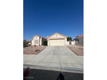 Inviting single-story home featuring a two-car garage and low maintenance desert landscaping in the front yard at 4724 Victoria Beach Way, Las Vegas, NV 89130