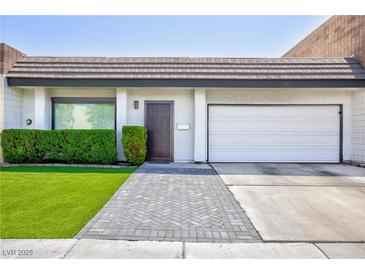 Charming home features a two-car garage, manicured lawn, and lovely front entrance at 3380 Kensbrook St, Las Vegas, NV 89121