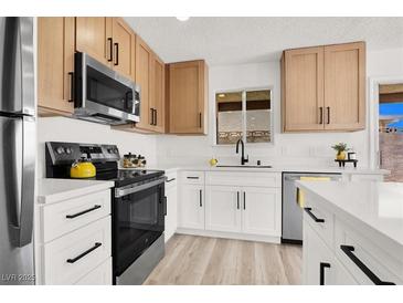 Bright kitchen with stainless steel appliances, white countertops, and modern cabinetry at 5030 E Hacienda Ave, Las Vegas, NV 89122