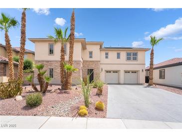 Modern two-story home featuring a stone facade, a two-car garage, and desert landscaping with palm trees at 8824 Killians Greens Dr, Las Vegas, NV 89131