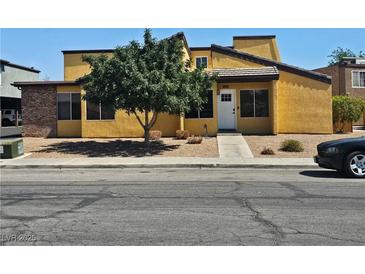 A charming yellow two-story home featuring a mature shade tree, low maintenance landscape and inviting entry at 1480 Hialeah Dr # B, Las Vegas, NV 89119
