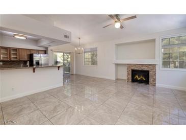 Bright open living room with tile floors, fireplace, and sliding door to the patio at 1705 King James St # 203, Las Vegas, NV 89144