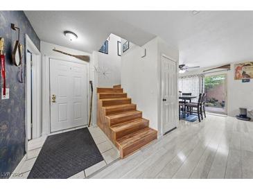 Inviting entryway with hardwood stairs, neutral paint, and a glimpse of the dining area at 3363 Pavlo St, Las Vegas, NV 89121