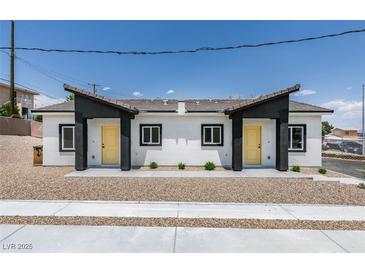 Charming duplex featuring matching front doors, landscaped yard and a modern exterior color palette at 367 N 16Th St, Las Vegas, NV 89101